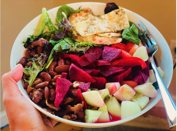 A colorful homemade meal with vegetables, beans, and greens